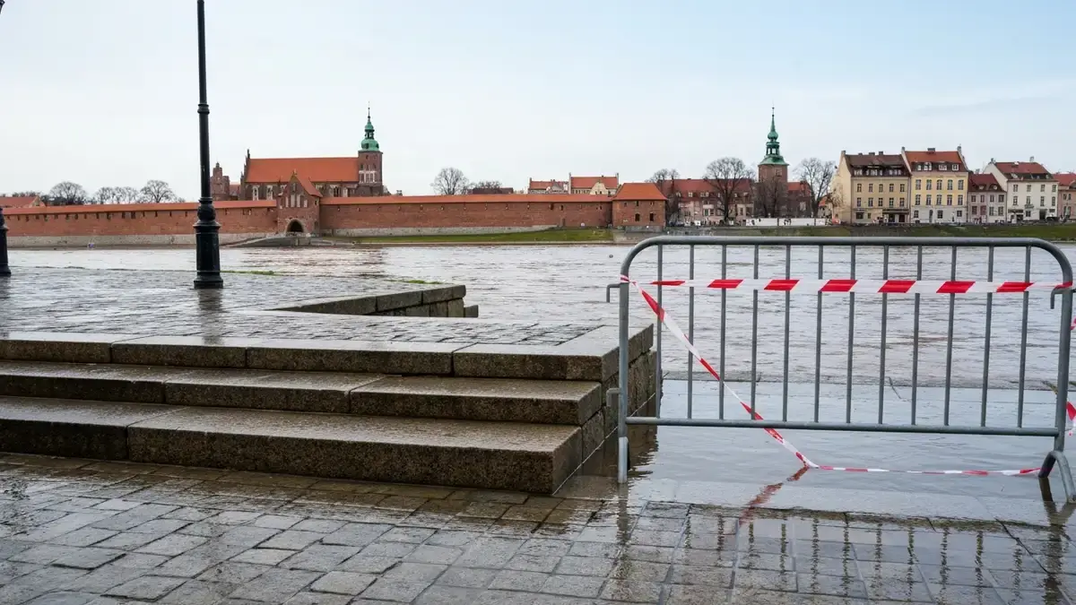 Zamkniete bulwary nad wezbrana Wisla w Toruniu z barierkami i panorama Starego Miasta